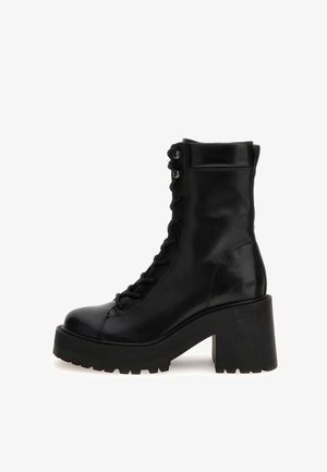Stivali alla caviglia in pelle nera con una suola a piattaforma spessa e lacci robusti. Presentano una finitura liscia e una suola robusta per una buona aderenza.