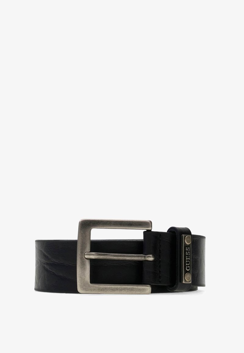 Ceinture en cuir noir avec une grande boucle carrée en métal argenté et une petite plaque métallique gravée avec "GUESS".