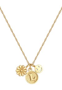 Gouden ketting met een gedraaide schakel, met drie bedels: een bloem, een "L" hanger en een glimlachend gezicht, allemaal met gestructureerde details.