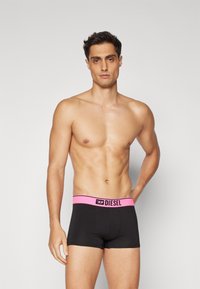 Μαύρες μποξεράκι εσώρουχα με ροζ και μαύρη ελαστική μέση, που φέρει το λογότυπο "DIESEL". Μαλακό, ελαστικό ύφασμα με άνετη εφαρμογή.