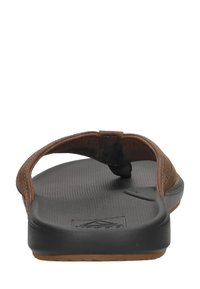 Tongs en cuir marron avec une semelle en caoutchouc noir texturé, dotées d'un coussin de pieds et d'un design de lanière simple.