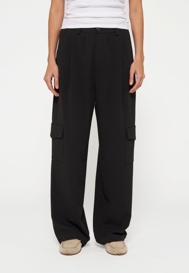 Schwarze, weite Cargo-Hosen mit vorderen Falten, zwei Seitentaschen und einem sicheren Knopfverschluss. Hergestellt aus einem glatten, leichten Stoff.