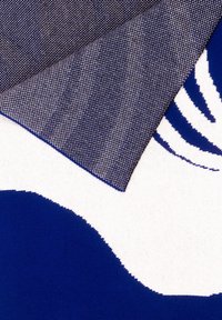 Tkanina z ciemnoniebieskim i białym wzorem falistym. Materiał ma gładką teksturę i złożony róg odsłaniający wzór w jodełkę pod spód.