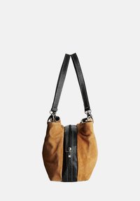 Bolso de mano de ante marrón con detalles en cuero negro en el cierre y correas. Presenta una forma curva, acentos texturizados y herrajes plateados.