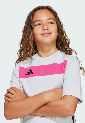 Jeugd sport t-shirt in het wit met een roze horizontale streep. Voorzien van een zwart logo en ribbelstructuur op de streep. Korte mouwen, relaxed fit.