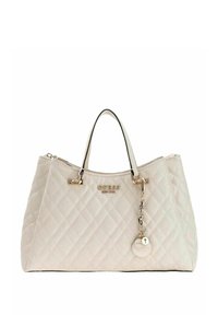 Sac à main beige matelassé avec double poignée supérieure, accents dorés et un charm décoratif. Présente une forme structurée et une texture lisse.