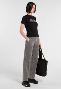 Sort kortærmet t-shirt med "Dickies Durable Clothing" logo, parret med højtaljede, løse grå jeans og sort fodtøj. Sort tote taske.