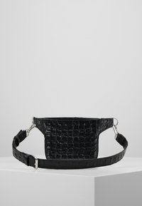 Czarna torebka typu crossbody z ekologicznej skóry, z fakturą w kształcie krokodylej skóry, prostokątnym kształtem i regulowanym paskiem z srebrnymi akcentami.