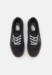 Černé semišové tenisky s bílými šněrovadly, s logem na jazyku a gumovou podrážkou. Hladký povrch s klasickými designovými prvky.