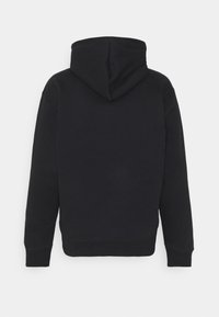 Černá mikina s kapucí, dlouhými rukávy, šňůrkou u kapuce a žebrovanými manžetami a spodním lemem. Tkanina vypadá měkká a texturovaná. Žádné viditelné logo.