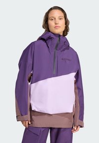 Lila und lilafarbene color-blocked Jacke mit Kapuze, hergestellt aus wasserabweisendem Material. Mit einem Reißverschluss vorne und verstellbaren Zugbändern.