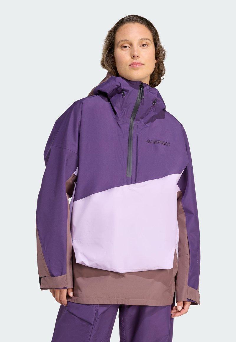 Lila und lilafarbene color-blocked Jacke mit Kapuze, hergestellt aus wasserabweisendem Material. Mit einem Reißverschluss vorne und verstellbaren Zugbändern.