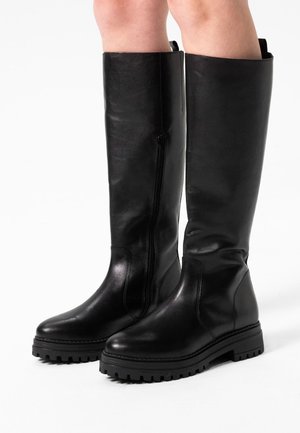 Knee-high black leather boots with a smooth finish, side zipper, and rugged rubber soles. Features a chunky block heel and sturdy design.