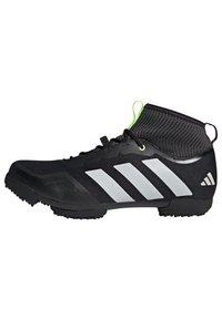 Baskets noires de sport avec un design montante, tige texturée, trois bandes blanches, accent vert sur le col et semelle en caoutchouc.