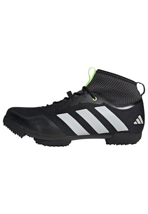 Scarpe da ginnastica nere con design alto, parte superiore texturizzata, tre strisce bianche, dettaglio verde sul colletto e suola in gomma.