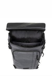 Zaino con motivo a quadretti bianco e nero, chiusura a roll-top, tasca esterna, tessuto testurizzato e fibbie laterali regolabili.