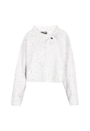 Baltas trumpas megztinis su dėmėtu juodu raštu, turintis apykaklę ir surišimo detalę, pritvirtintą mygtuku priekyje. Minkšta tekstūra.