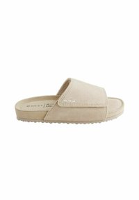 Beige nubukist sussand, mille laia ülemise rihmaga, pehme sisetallaga ja tekstureeritud kummist väljalõikega. Soodustavad minimaalsed õmblusdetailid.