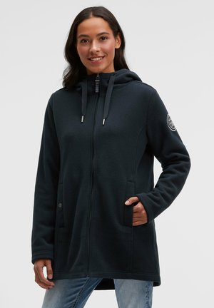 Dark fleece jacket with a hood, zip closure, side pockets, and logo patch on the sleeve. Smooth texture and fitted design.