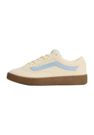 Lage beige sneaker met lichtblauwe zijstreep, crèmekleurige veters en dikke bruine rubberen zool, getoond vanaf de buitenkant op een witte achtergrond.