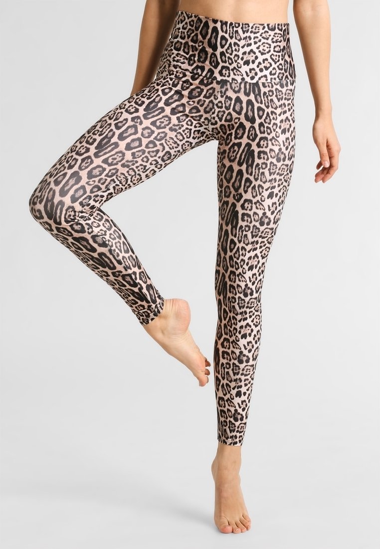 Legginsy z wysokim stanem wykonane z lekkiego materiału w wzór lamparta w odcieniach beżu i czerni, charakteryzujące się gładką, elastyczną teksturą.