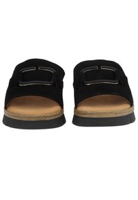 Czarne zamszowe sandały na płaskiej podeszwie z podwójnymi paskami z metalowymi akcentami, jasnobrązową wkładką i teksturowaną czarną gumową podeszwą.