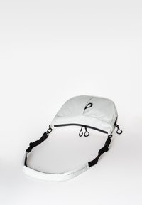 Weißes gepolstertes Sling-Bag mit konturiertem Design, schwarzem Reißverschluss und verstellbarem Träger. Verfügt über kleine Schlaufen zur Befestigung. Glatte Textur.