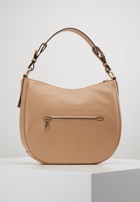 Tan leather shoulder bag with a curved shape, gold hardware accents, and a front zip pocket. Adjustable strap for versatile carry options.