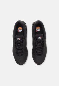 Černé sportovní boty s texturovaným síťovaným svrškem, kulatými tkaničkami, viditelným vzduchovým odpružením a logem na jazyku.