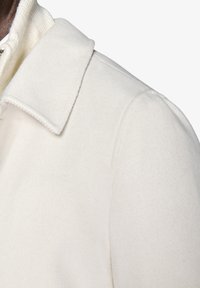 Hvid uld-blend frakke med struktureret krave og blød tekstur, med synlige syninger og et rent, minimalistisk design.