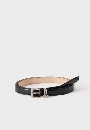 Ceinture en cuir noir avec boucle argentée disposée en cercle sur un fond blanc.