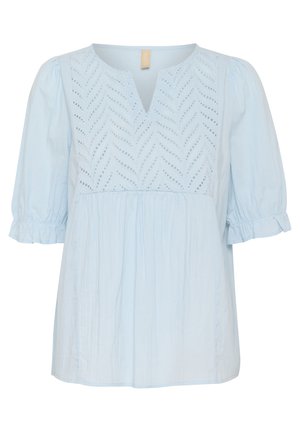 Blusa azzurra con scollo a V e maniche a palloncino corte. Presenta un'intricata ricamo a occhio di pernice con motivo a foglia sul corpetto. Texture morbida.