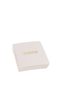 Caja de joyería cuadrada blanca con el texto dorado "amor" centrado en la tapa sobre un fondo blanco liso.