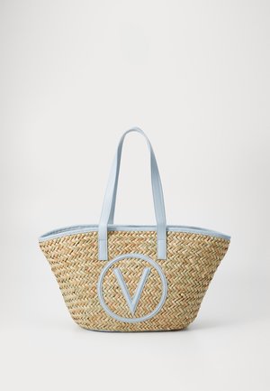 Sac fourre-tout en paille tressée avec une bordure et des anses bleu clair, arborant un grand logo circulaire "V" au centre avant.