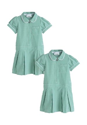 Dos vestidos escolares de manga corta a cuadros verdes y blancos, con cuellos, cremalleras delanteras y bolsillos en el pecho con pequeños lazos.