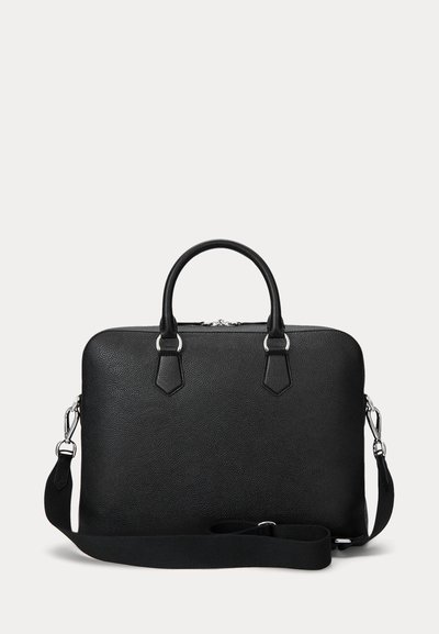 Mallette en cuir noir texturé avec double poignées, ferrures argentées, et bandoulière ajustable détachable sur fond blanc.
