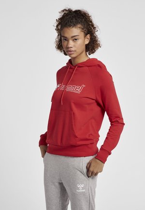 Roter Kapuzenpullover mit einer Fronttasche und weißem Logo auf der Brust, kombiniert mit hellgrauen Jogginghosen, die ein kleines weißes Logo aufweisen.