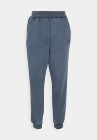 Navy blue sweatpants made of soft material, featuring a ribbed waistband, side pockets, and elastic cuffs at the ankles. Subtle branding detail.