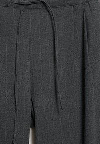 Pantaloni di lana grigia con righe verticali, dotati di vita con coulisse e pieghe per una maggiore texture. Tessuto liscio, design sartoriale.