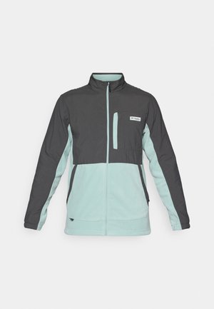 Kesäjakku keskipainoisena harmaana ja mintunvihreänä, jossa on täyspitkä vetoketju, korkea kaulus ja rintatasku. Pehmeä rakenne, jossa on kontrastiväriset paneelit.