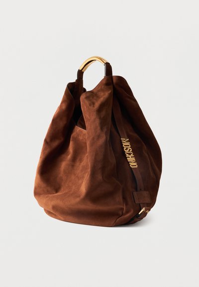 Καφέ σουέντ τσάντα χειρός με χρυσές μεταλλικές λεπτομέρειες και κοντή λαβή, με κάθετο λουρί με χρυσά γράμματα "MOSCHINO".