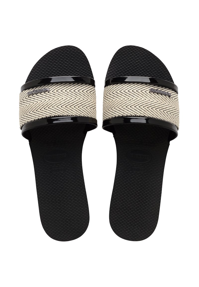 Musta sandaalit, joissa on kudottu vaalean beige vyö herringbone-kuviolla ja kiiltävät mustat yksityiskohdat. Rakeinen pohja tarjoaa pidon ja mukavuutta.