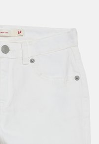 Άσπρο τζιν παντελόνι φαρδιάς γραμμής με μεταλλικό κουμπί και καρφίτσες, μπροστινή τσέπη και ετικέτα μεγέθους με την ένδειξη 8A.