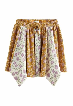 Jupe jaune moutarde et blanche avec des imprimés floraux violets, taille élastique et cordons à nouer, présentant des panneaux de tissu pointus.