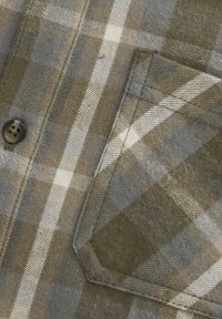Zielona i szara koszula w kratę, wykonana z gładkiego materiału, z guzikiem i detalem kieszonki. Wzory obejmują przecinające się paski.