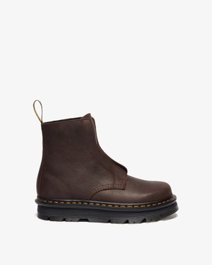 Braune Leder-Ankle-Boots mit elastischen Seiteneinsätzen, strukturierten Oberflächen, Zuglasche und kontrastierenden gelben Nähten auf einer schwarzen Gummisohle.