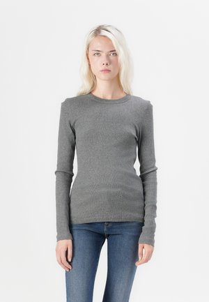 Grijze langermige top van ribbelsweefsel, met een ronde halslijn en aansluitende silhouette, gecombineerd met blauwe denim jeans.