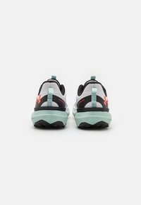 Athletic shoes with a white mesh upper, black accents, and a mint green sole. Features a logo and distinctive heel tab for easy wearing.
