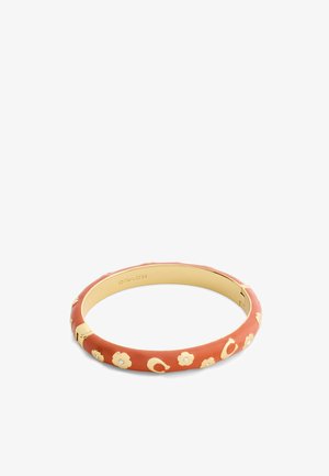 Bracelet jonc ton or avec revêtement en émail orange brûlé, décoré de petites fleurs dorées et de cristaux incrustés, fermoir à charnière, logo Coach à l'intérieur.