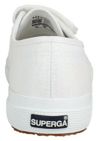 Baskets Superga blanches avec une surface texturée et irisée. Elles disposent d'une semelle en caoutchouc et d'un patch logo noir sur le talon.